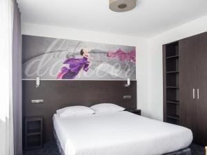 sypialnia z białym łóżkiem i obrazem na ścianie w obiekcie B&B HOTEL Bytom w Bytomiu