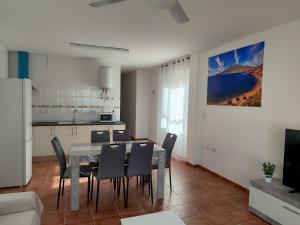 Una cocina y un comedor con mesa y sillas. en Apartamento El Flamenco Azul Cabo de Gata, en Almería