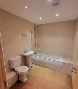 a bathroom with a toilet and a tub and a sink at Wild Atlantic Apartments Port House Letterkenny in Letterkenny