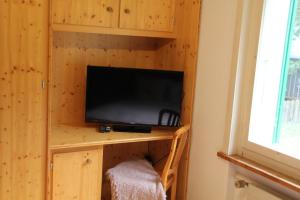 a tv on a wooden shelf in a room at 5Min Walk To Audi FIS Ski World Cup Swiss Studio in Adelboden