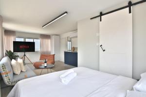 - une chambre avec un lit blanc et un salon dans l'établissement ROOFTOP 42 - Studio, à Haïfa
