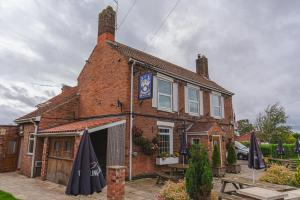a brick building with umbrellas in front of it at Eyre arms 