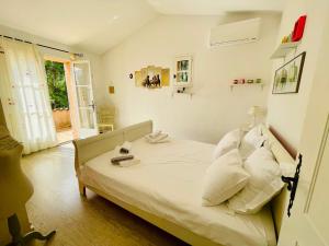 a bedroom with a bed with white sheets and a window at Villa Kogayon in Le Bar-sur-Loup