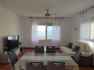 una sala de estar con una mesa y un sofá en Apartamento El Flamenco Azul Cabo de Gata, en Almería