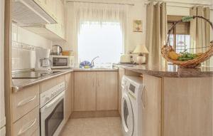 a kitchen with a dishwasher and a washer and dryer at 2 Bedroom Stunning Apartment In Rojales in Rojales