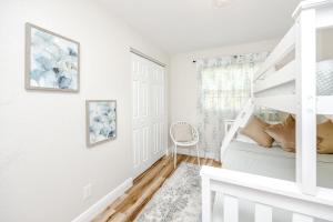 - une chambre blanche avec des lits superposés et un escalier dans l'établissement 1032 3rd Ave SW, à Largo