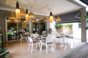 a restaurant with white chairs and tables and chandeliers at Villa Ayaba in Abidjan