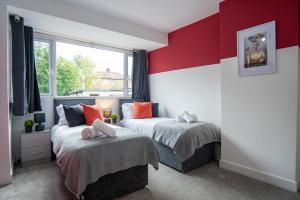 two beds in a room with red and white walls at Sheldon House NEC, BHX, jlr perfect for contractors in Birmingham