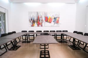 een kamer met tafels en stoelen en een schilderij aan de muur bij Villa Ayaba in Abidjan