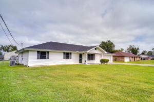 een wit huis met een grote tuin bij Charming Lake Charles Home with Patio and Grill in Lake Charles