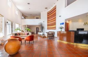 a living room with a couch and a table and chairs at Hotel Altos de la Viña in San Salvador de Jujuy