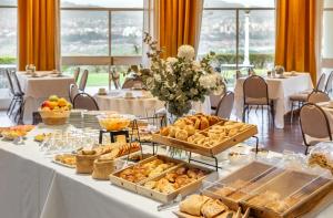 een tafel met diverse zoete deegwaren en brood erop bij Hotel Altos de la Viña in San Salvador de Jujuy