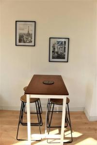 a table and two stools in front of a wall at Magnifique appartement in Le Havre