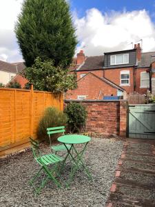 a green table and two chairs in a backyard at Equipped 5bed 2bath House in Coventry City FREE PARKING AMENITIES ROADLINKS SMART TV WI-FI in Coventry