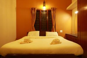 a bedroom with a bed with two towels on it at MM Resorts in Yercaud