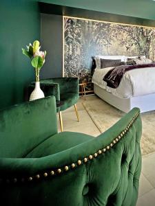 a living room with a green couch and a bed at Die Heerenhuys Guest Suites in Stellenbosch