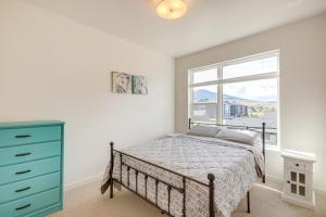 a bedroom with a bed with a blue dresser and a window at Modern Livingston Condo Near Yellowstone River! in Livingston