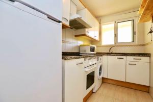 a kitchen with a refrigerator and a washer and dryer at 2 bedrooms apartement at Denia 300 m away from the beach with shared pool and furnished terrace in Denia