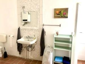 een witte badkamer met een wastafel en een spiegel bij Finca in Brandenburg Ferienhaus mit Sauna in Baruth