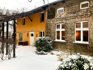een huis met sneeuw op de grond ervoor bij Finca in Brandenburg Ferienhaus mit Sauna in Baruth