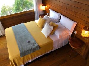 a bedroom with a bed with a wooden wall at Vilaria Tatajuba in Tatajuba