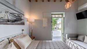 a bedroom with a bed and a couch and a tv at villa lord in Pollonia