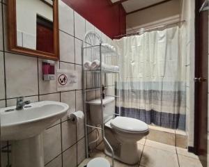 a bathroom with a toilet and a sink at Casa Cafetal Aeropuerto in Alajuela