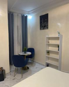 a room with a table and chairs and a shelf at Le doux refuge in Dakar