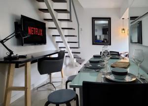 a dining room with a table with chairs and a television at BGC Central Comforts in Manila