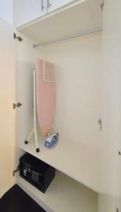 un estante en una habitación con un bate de béisbol en BGC Central Comforts, en Manila