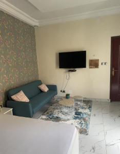 a living room with a couch and a flat screen tv at Le doux refuge in Dakar