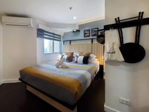 a bedroom with a bed with a teddy bear on it at BGC Central Comforts in Manila