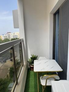 uma varanda com uma mesa branca e 2 cadeiras em Le doux refuge em Dakar