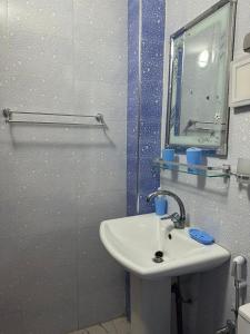 y baño con lavabo, espejo y ducha. en Le doux refuge en Dakar