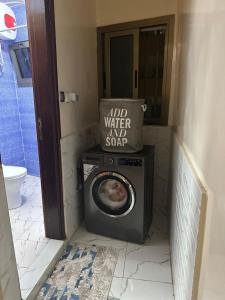 a washing machine in the corner of a bathroom at Le doux refuge in Dakar