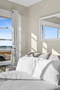 a bedroom with a bed with a view of the ocean at Northern Beaches Surfer's Sanctuary Studio in Deewhy