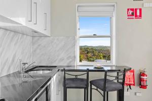 a kitchen with two chairs and a counter with a window at Northern Beaches Surfer's Sanctuary Studio in Deewhy