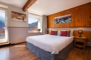 a bedroom with a large bed with wood paneling at Chalet Hôtel La Sapinière in Chamonix-Mont-Blanc