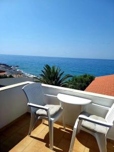 two chairs and a table on a balcony with the ocean at Agia Roumeli Hotel in Agia Roumeli