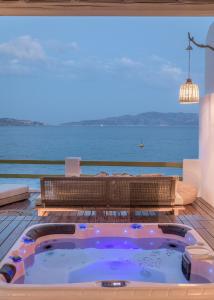 bañera de hidromasaje en una terraza con vistas al océano en villa lord en Pollonia