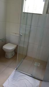 uma casa de banho com um WC e uma cabina de duche em vidro. em Pousada Hilário em São João del Rei