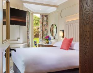 a bedroom with a large white bed and a window at Waterloo Town House & Suites in Dublin