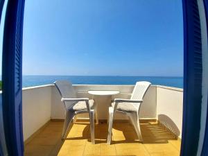 a table and two chairs on a balcony with the ocean at Agia Roumeli Hotel in Agia Roumeli +37 photos