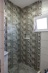 y baño con ducha y puerta de cristal. en Kenzy Apartments en Ulcinj