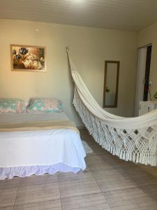 1 dormitorio con cama colgante y espejo en Suíte Nativa - Flecheiras en Flecheiras