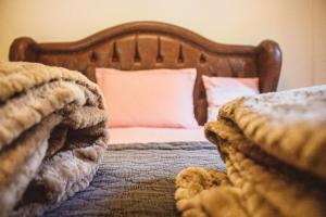 1 cama con cabecero de madera y almohada rosa en Sítio Estância Beija flor, en Floriano Simmer