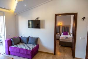 a living room with a purple couch and a bedroom at Kenzy Apartments in Ulcinj