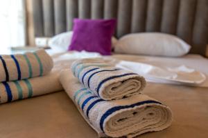 uma pilha de toalhas sentadas em cima de uma cama em Kenzy Apartments em Ulcinj