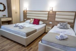 een slaapkamer met 2 bedden en handdoeken bij Kenzy Apartments in Ulcinj