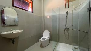 a bathroom with a toilet and a sink and a shower at Homestay Pelangi Jimbaran in Jimbaran